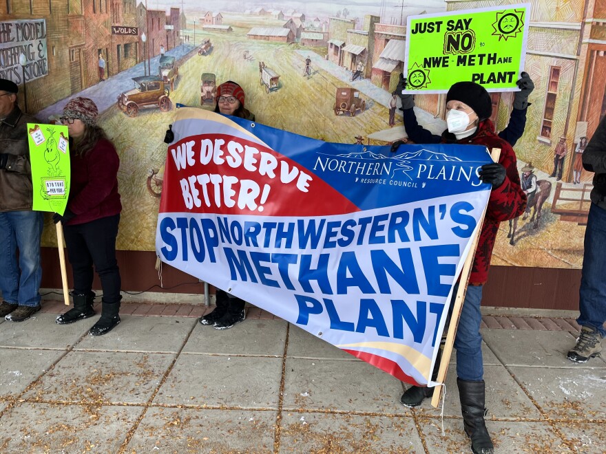 Laurel residents protest planned natural gas plant. Holding a sign thar says, "We deserve better! Stop Northwestern's methane plant."