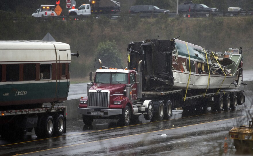 A damaged train car is shown on the bed of a truck along I-5 South on Tuesday, December 19, 2017, in Dupont. 