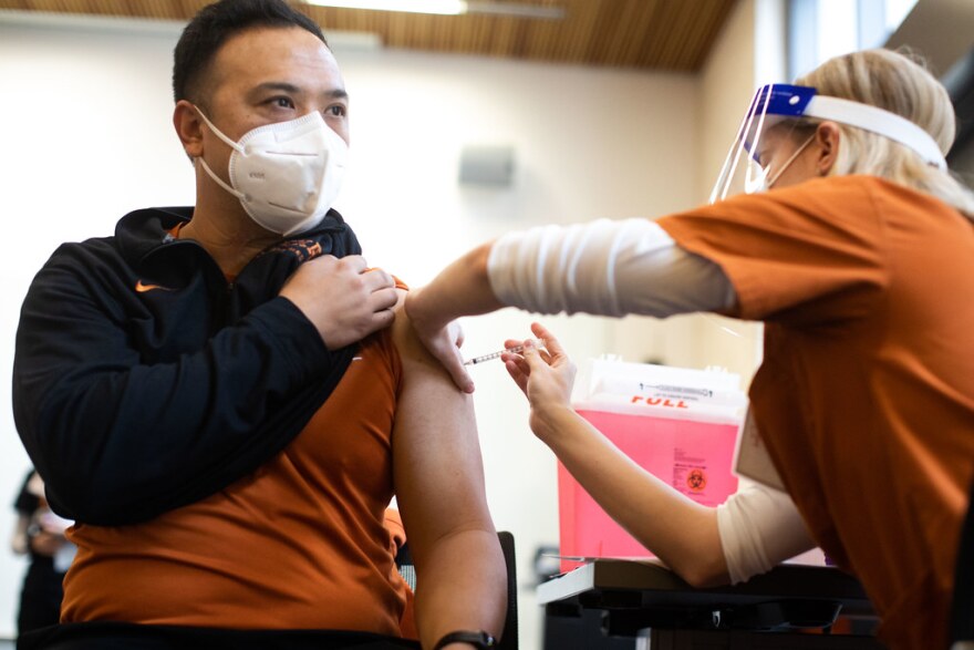 UT-Austin football athletic trainer Johnnathan Tran receives the COVID-19 vaccine Pfizer BioNTech during injections to healthcare workers at Dell Medical School on Dec. 15, 2020.