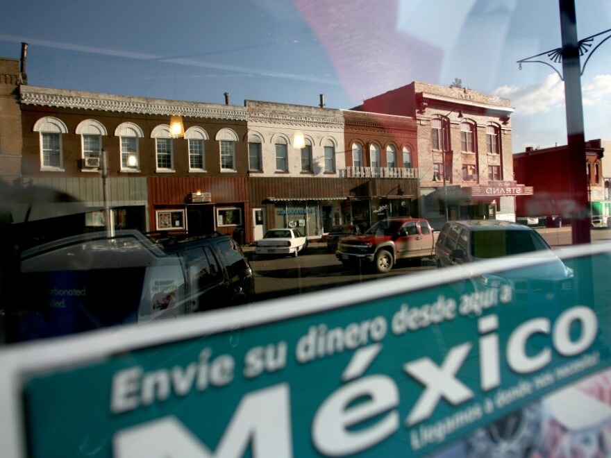 <p>Sending money to relatives in Mexico is a popular way for families to support each other. West Liberty's East 3rd Street is reflected in this window. </p>