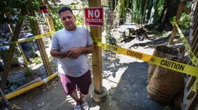 Amid caution tape and no trespassing signs, Marvin Moreno stands outside the apartment where he lived in East Boston. His landlord pressured him to leave, despite the eviction moratorium. (Jesse Costa/WBUR)