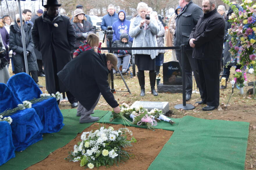 A man and child lay flowers on the headstone for the 2,411 fetal remains that were found in Dr. Ulrich Klopfer's garage in September 2019. The burial service was at Southlawn Cemetery in South Bend on Wednesday, Feb. 12, 2020.