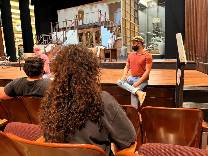 UH Mānoa graduate student and Hawaiian theatre major Ākea Kahikina sitting on stage during rehearsals.