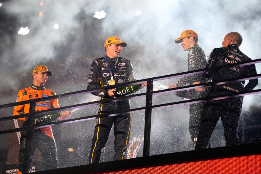 From left, second place finisher McLaren driver Lando Norris of Great Britain, first place finisher Red Bull driver Max Verstappen of the Netherlands, and third place finisher Mercedes driver George Russell of Great Britain celebrate after the Formula One Las Vegas Grand Prix auto race, Saturday, Nov. 22, 2025 in Las Vegas.