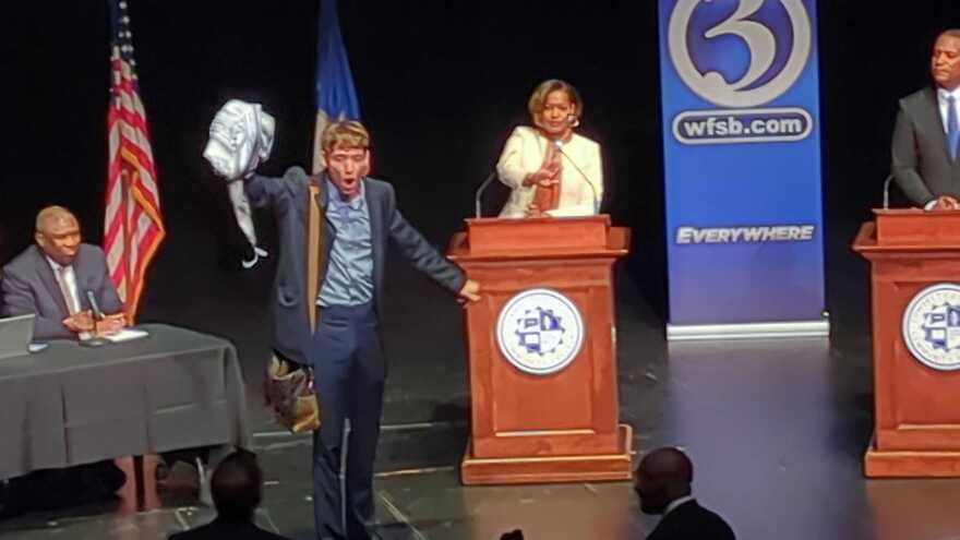 A protestor interrupts the 5th District Congressional debate between Democratic incumbent Jahana Hayes and Republican challenger George Logan at Naugatuck Valley Community College in Waterbury, Conn., on Wednesday October 9, 2024.