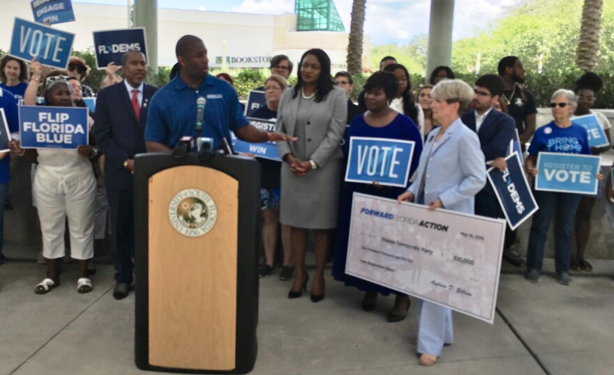 Andrew Gillum presents a check to Florida Democratic Party Chair Terrie Rizzo for voter registration efforts.