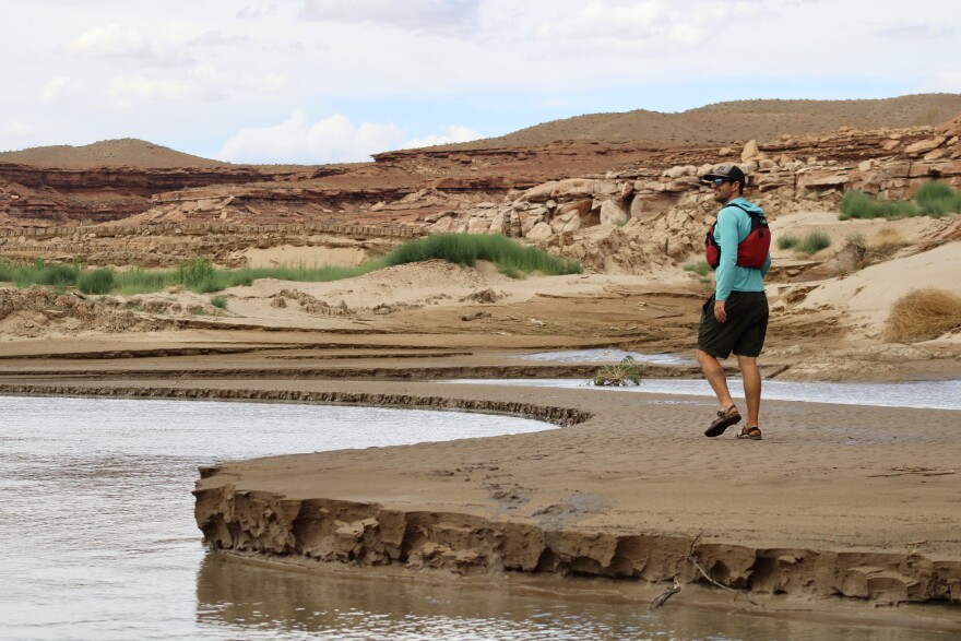 Eric Balken, executive director of Glen Canyon Institute, walks along a sandbar once submerged by Lake Powell. As the reservoir drops to record lows, it draws out of areas that were underwater for decades.