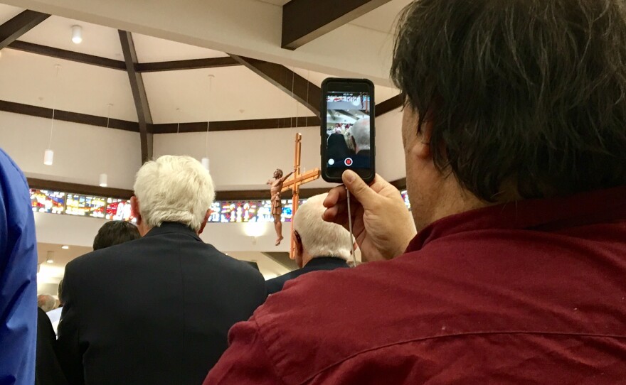 A man records the ordination of Bishop Thomas Zinkula on his cellphone.