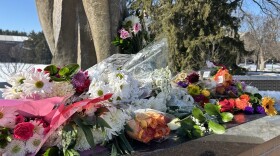 Flowers cover the base of the Spartan statue outside Spartan Stadium in honor of the 2023 campus shooting victims.