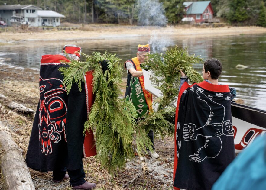 Dancers place cedar boughs on the long bow of Petersburg’s new canoe.