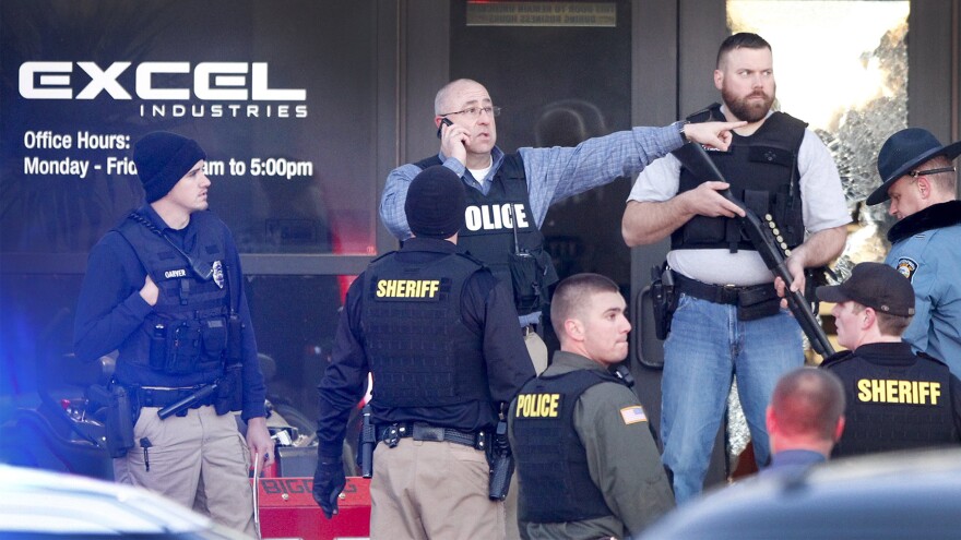 Police guard the front door of Excel Industries in Hesston, Kan., where a gunman reportedly killed three people before being shot to death by a police officer.