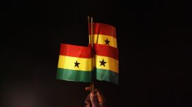 A Ghana fan holds up Ghanaian flags during the international friendly match between Ghana and Mexico at Craven Cottage in London, England. 