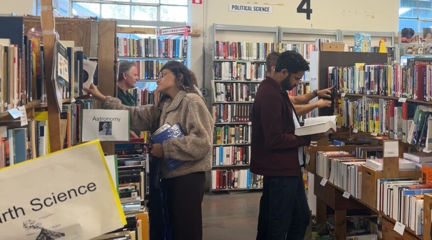 Shoppers inspect books for sale on Saturday, Oct. 25, 2025. “There’s something for everyone,” said Ellen Smith, one of 200 Friends of the Library volunteers at the event. (Shaine Davison/WUFT News)