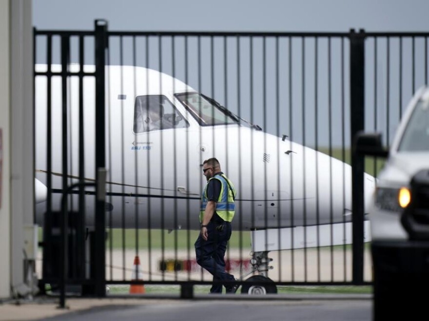 An airline worker walks past a plane. 