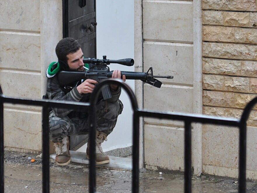 A Syrian rebel aims his weapon during a battle with the Syrian government forces at Rastan area in Homs province, central Syria, on Jan. 31.