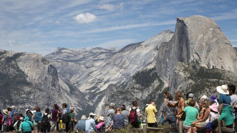 Crowds gather in front of a mountain backdrop. 
