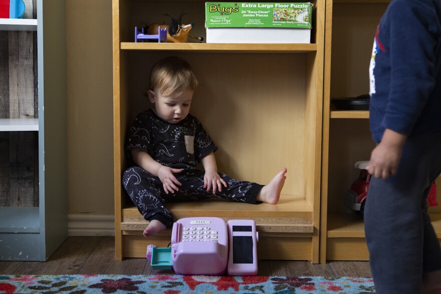 A child sits in a bookshelf at Kid's Castle Family Daycare and Preschool in Pflugerville in 2022.