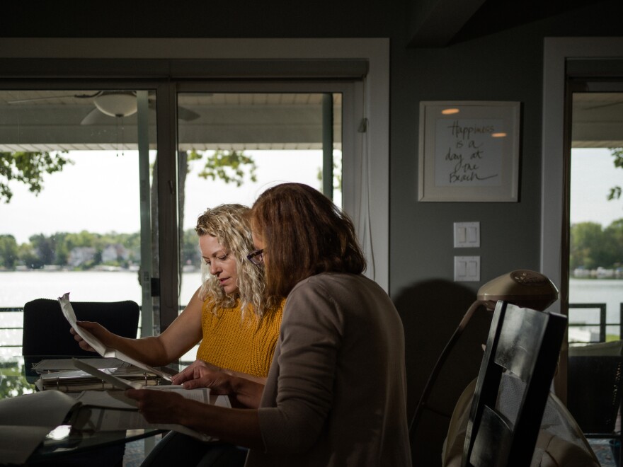 Nicole Sullivan (left) and her neighbor, Catherine Shannon, look over property documents in Mundelein, Ill. Together, they convinced a state lawmaker to sponsor a bill to remove the racial covenants from the record.