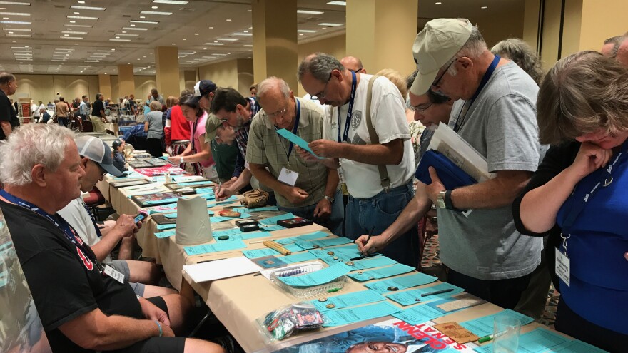 Collectors bid on items at a silent auction at the American Political Items Collectors conference in Springfield. 