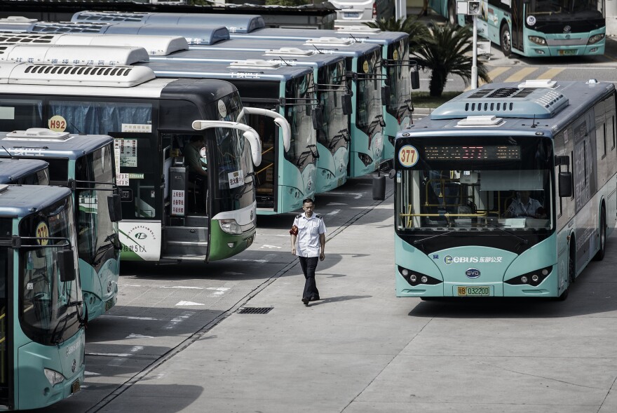 A worker walks past a BYD electric bus at a public transportation hub in Shenzhen.