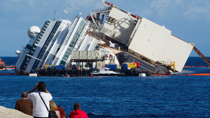 The view Monday from shore as work began to pull the Costa Concordia upright. The box-like structure on the ship's port side is one of the refloating caissons that will stabilize the ship.