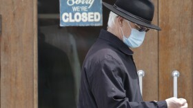 a man walks past a closed business in Shaker Heights, Ohio. Commissioner Alicia Reece proposed the legislation in order to keep up with Ohio's 87 other counties.