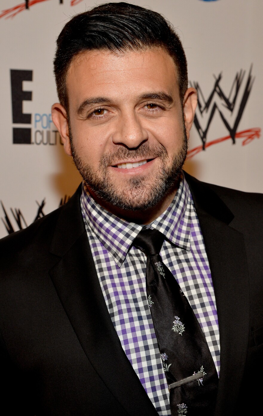 The Travel Channel's Adam Richman, last year at a charity event in Los Angeles, had his new show indefinitely postponed after telling a critic via social media to "grab a razor blade and draw a bath."