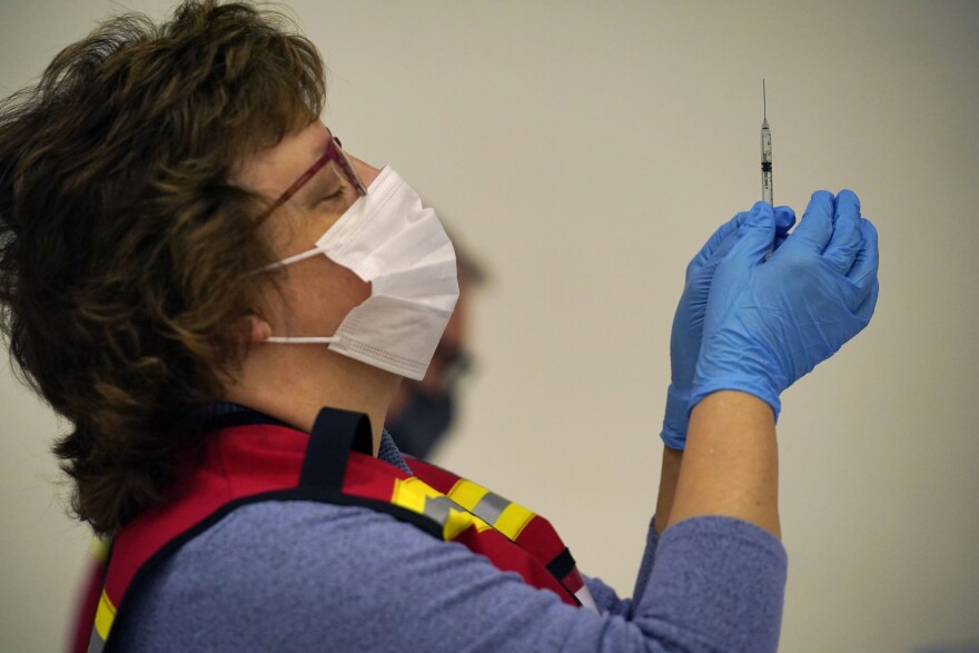 Jodi Philippon prepares a Pfizer-BioNTech vaccination at a COVID-19 clinic at the Augusta Armory, Tuesday, Dec. 21, 2021, in Augusta, Maine.