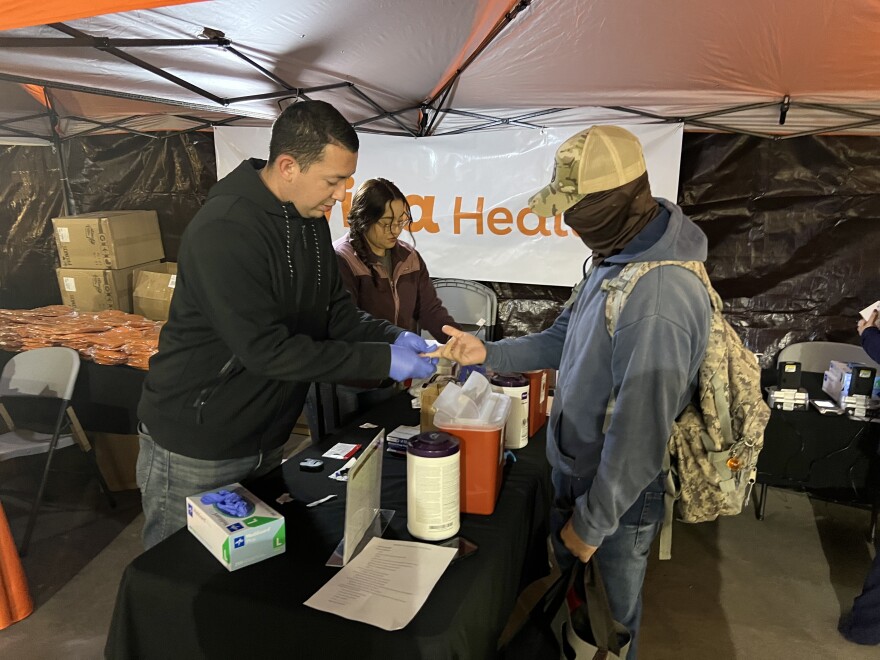 Jose Arredondo, left, a volunteer with Onvida Health, draws blood from an unidentified farmworker at the Dia Del Campesino in San Luis, Ariz. on Friday, Dec. 5, 2025.