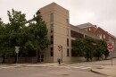 A concrete parking garage next to a brick-built building.