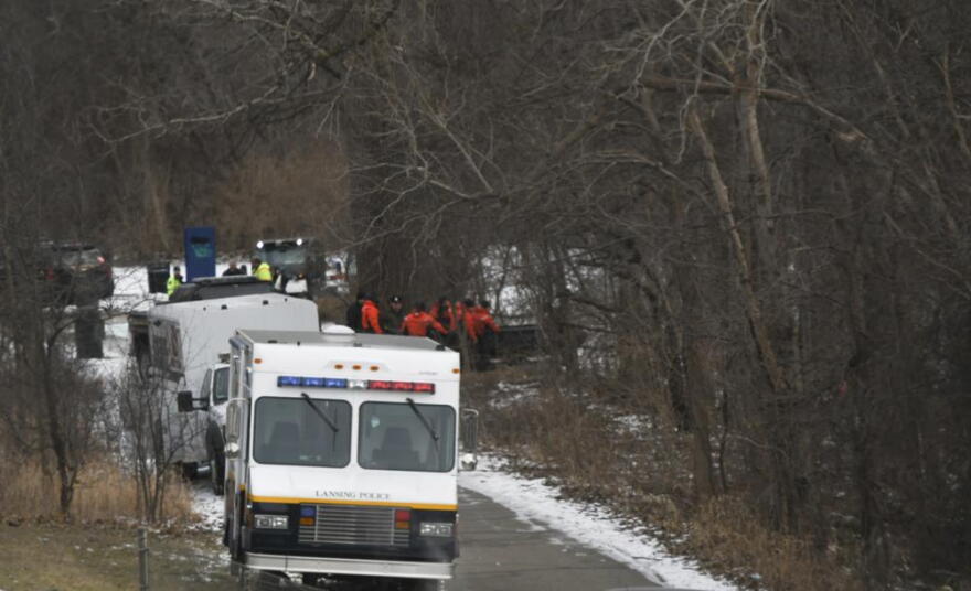 Search, rescue, and water recovery teams from multiple agencies, including the MSU Police Dept., Oakland County Sheriff, and Lansing Police, are staged along the Red Cedar River on Friday, Jan. 21, 2022 in East Lansing, Mich. A nearly three-month search for a missing college student who was visiting Michigan State University ended Friday with the discovery of a body in the Red Cedar River, police said. Authorities believe the body is Brendan Santo, 18, who was last seen leaving a residence hall late on Oct. 29.