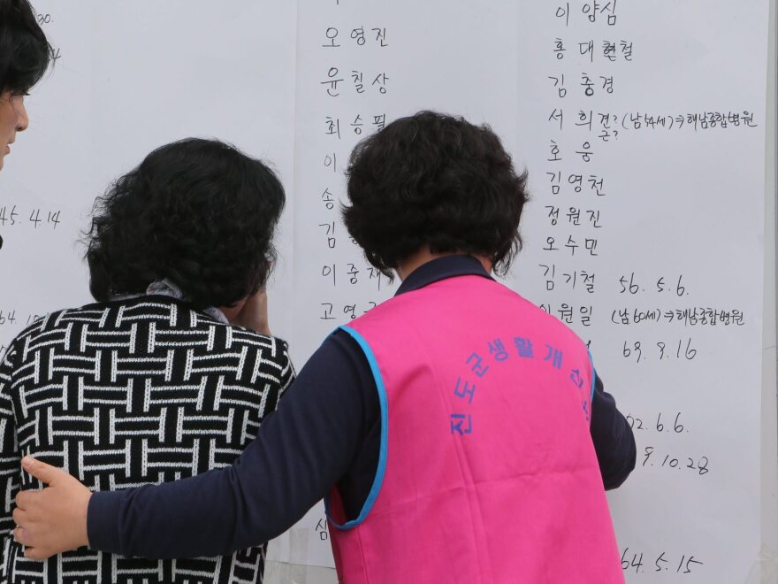 Family members of passengers on a South Korean ferry that sank look at lists of survivors on Wednesday.