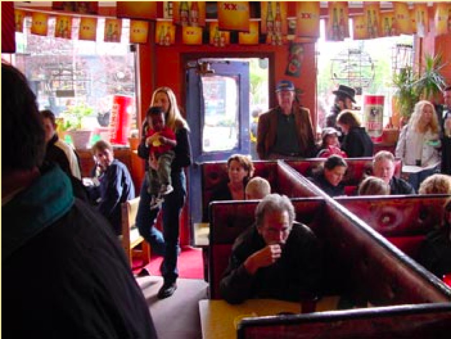 People inside a restaurant siting and walking around.