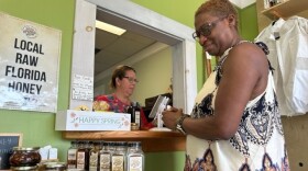 Michelle Davis-Singleton, right, buys honey from Christine Leach at Bee Friends.