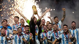 Argentina's Lionel Messi lifts the trophy after winning the World Cup final soccer match between Argentina and France at the Lusail Stadium in Lusail, Qatar, on Dec. 18, 2022.