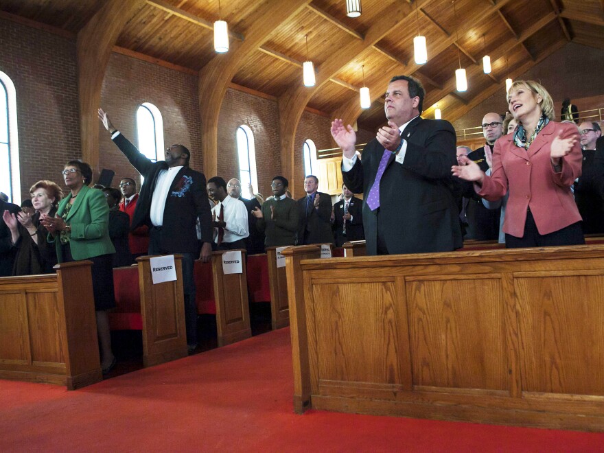 New Jersey Gov. Chris Christie joins Lt. Gov. and Secretary of State Kim Guadagno (right) at a statewide prayer service in Newark marking the one-year anniversary of Superstorm Sandy, in October.