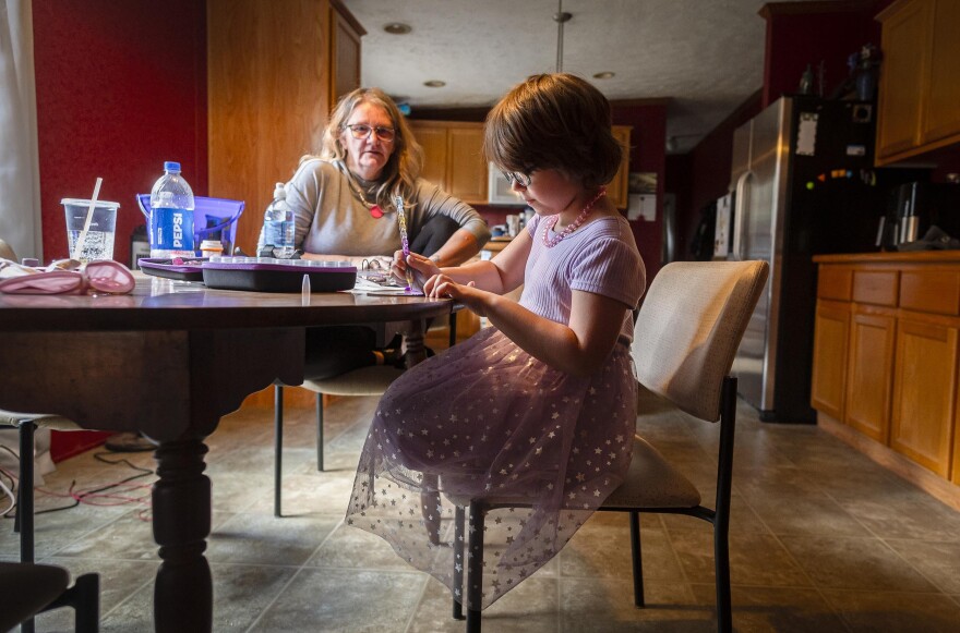 A woman and girl sit at a table