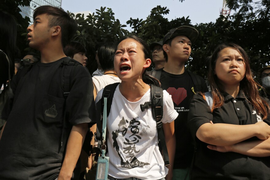 A protester cries after police removed barricades that protesters had set up to block main roads in Central district in Hong Kong on Tuesday.