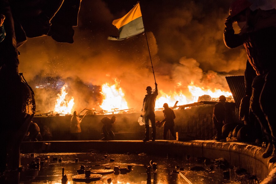 Amid fires set around Independence Square, known as the Maidan, in Kyiv, Ukraine, protesters demonstrate against the government of then-President Viktor Yanukovych in February 2014. Protesters called for Yanukovych's ouster over allegations of corruption and abandoning a trade agreement with the European Union.