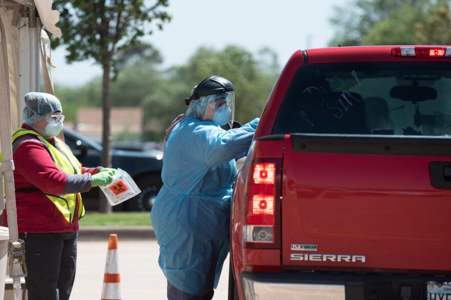 A nurse retrieves a nasal swab for a COVID-19 test at the Chickasaw Nation Purcell Health Clinic on April 28.