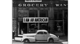 A large sign reads "I am an American" hangs in a window of a store in Oakland, CA in March 1942. The store was closed following orders to persons of Japanese descent to evacuate from certain West Coast areas.