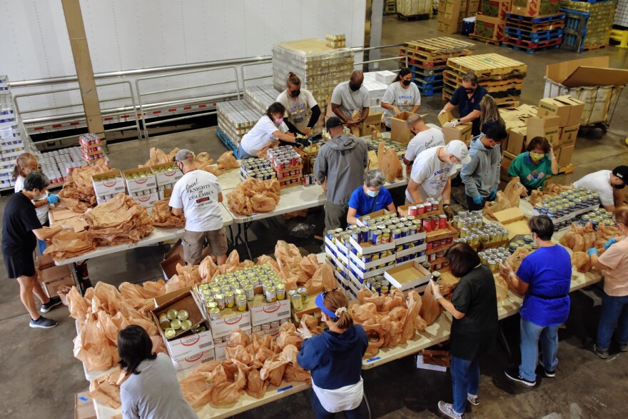 Hawaiʻi Foodbank volunteers prepare canned food items for distribution.