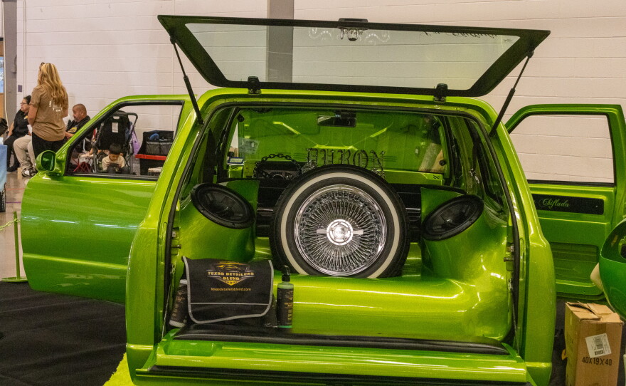 Trunk view of a green van with a wheel in the back, photo by Alexander Brown.