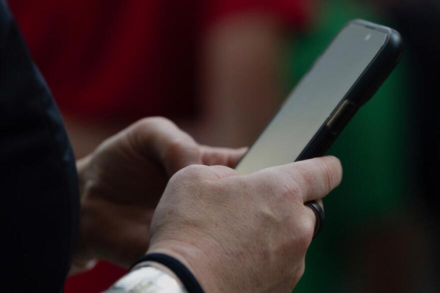 A person looks at their phone at Seattle–Tacoma International Airport on Sunday, June 1, 2025, in Seattle. (Jenny Kane/AP)