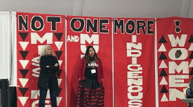  Women standing in front of a sign that reads, "Not one More! Missing and Murdered Indigenous Women."