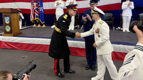 British Gen. Nick Perry shakes hands with U.S. Vice Admiral Doug Perry during the change of command on USS Nimitz.