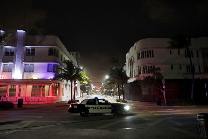 A police car patrols through the usual bustling South Beach ahead of Hurricane Irma in Miami Beach, Fla., Friday, Sept. 8, 2017. Florida asked 5.6 million people to evacuate ahead of Hurricane Irma, or more than one quarter of the state's population. A bill passed by the Florida Senate this week would require cities and counties to report evacuation orders, emergency shelter openings and a list of other emergency situations to the state. Reporting is not currently mandatory under state law.
