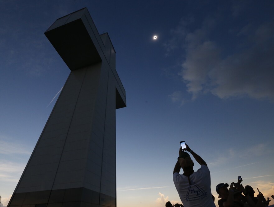 A total solar eclipse is seen above the Bald Knob Cross of Peace Monday, Aug. 21, 2017, in Alto Pass, Ill. Small towns and rural enclaves along the path of April’s 2024 total solar eclipse are steeling for huge crowds of sun chasers who plan to catch a glimpse of day turning into dusk in North America.