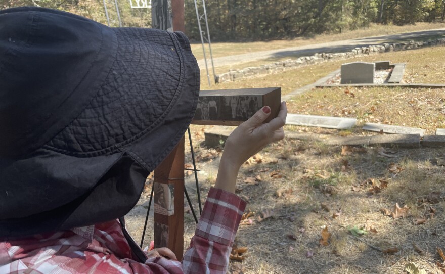 Martin-Moats gazes at the photos on the new cross set up at Harkey's Valley Cemetery.