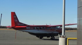 a small red and white plane parked on a tarmac